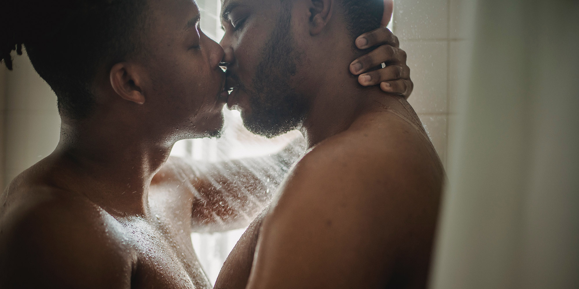 Two Black men kissing in the shower